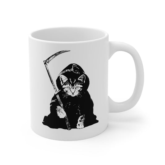 The left side view of a white alternative fashion coffee mug with an image of a kitten dressed as the grim reaper.